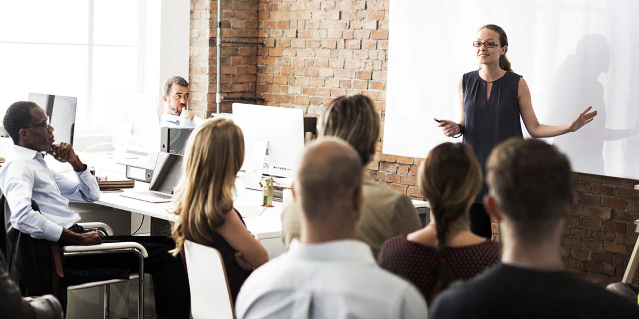 A group of managers attending a training session led by a woman